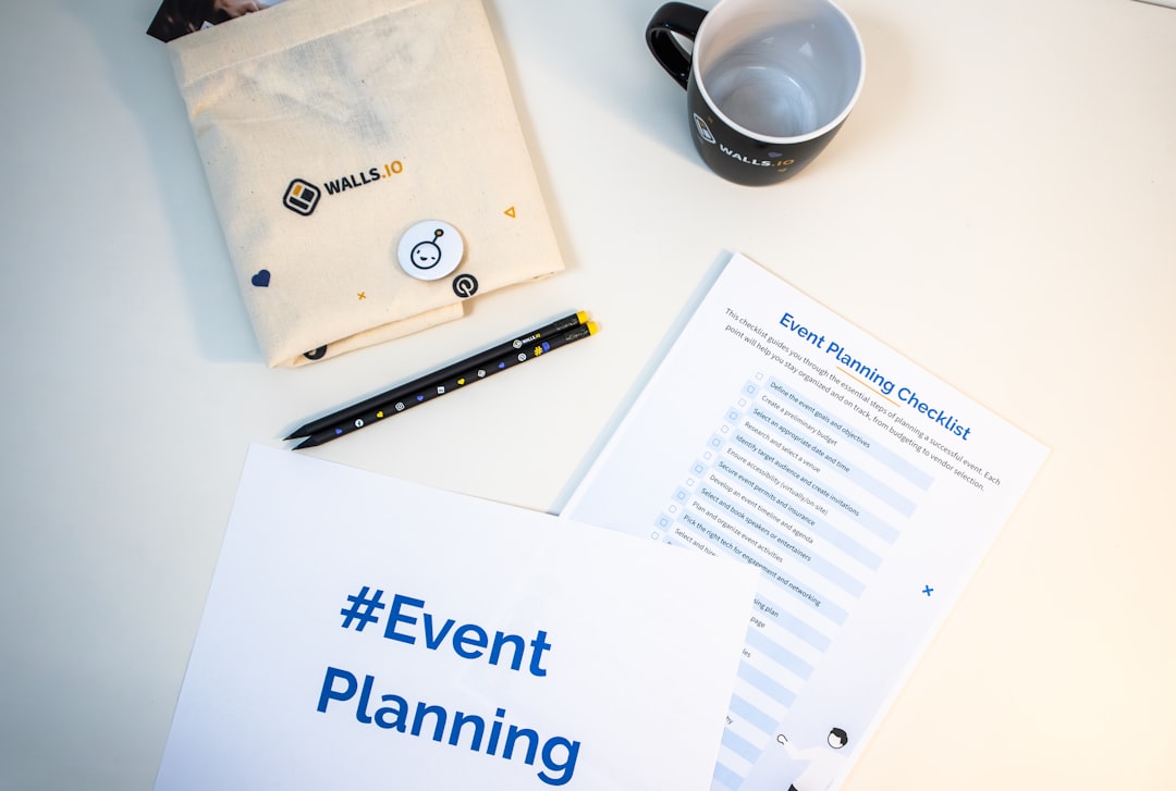 A desk with an event planning checklist, a piece of paper with the hashtag #EventPlanning and some branded merch